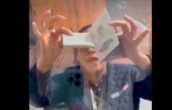 La funcionaria de Migración Colombia tomó el pasaporte de la afectada y mostró que tenía un desprendimiento parcial de la carátula. FOTO: TOMADA DE VIDEO.